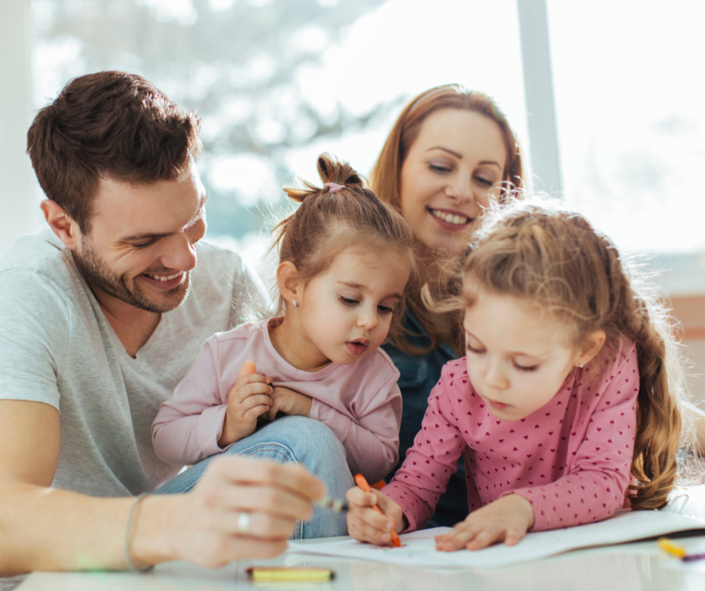 Parents with two young daughters doing a craft activity