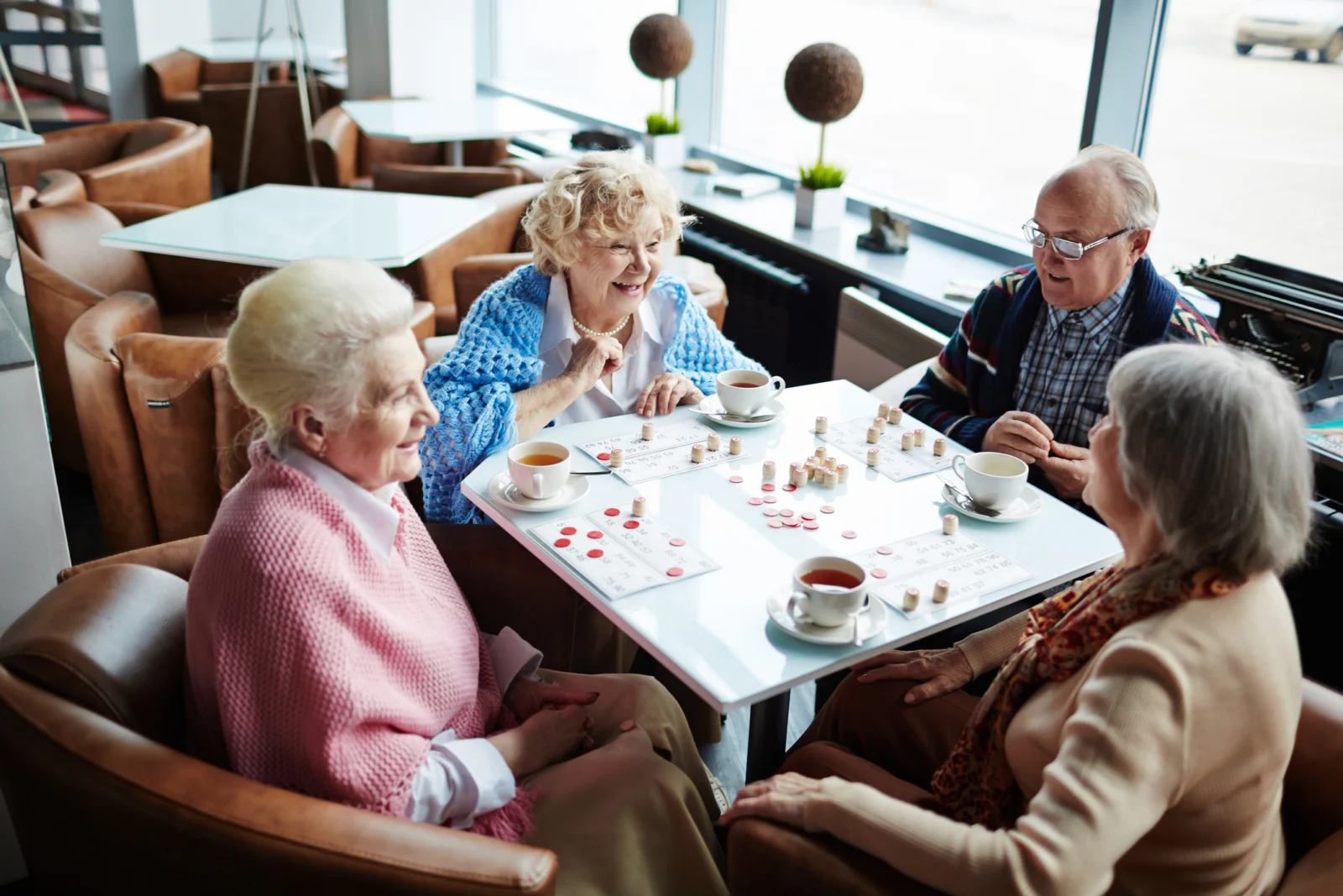 A group of older people sitting around a table playing bingo