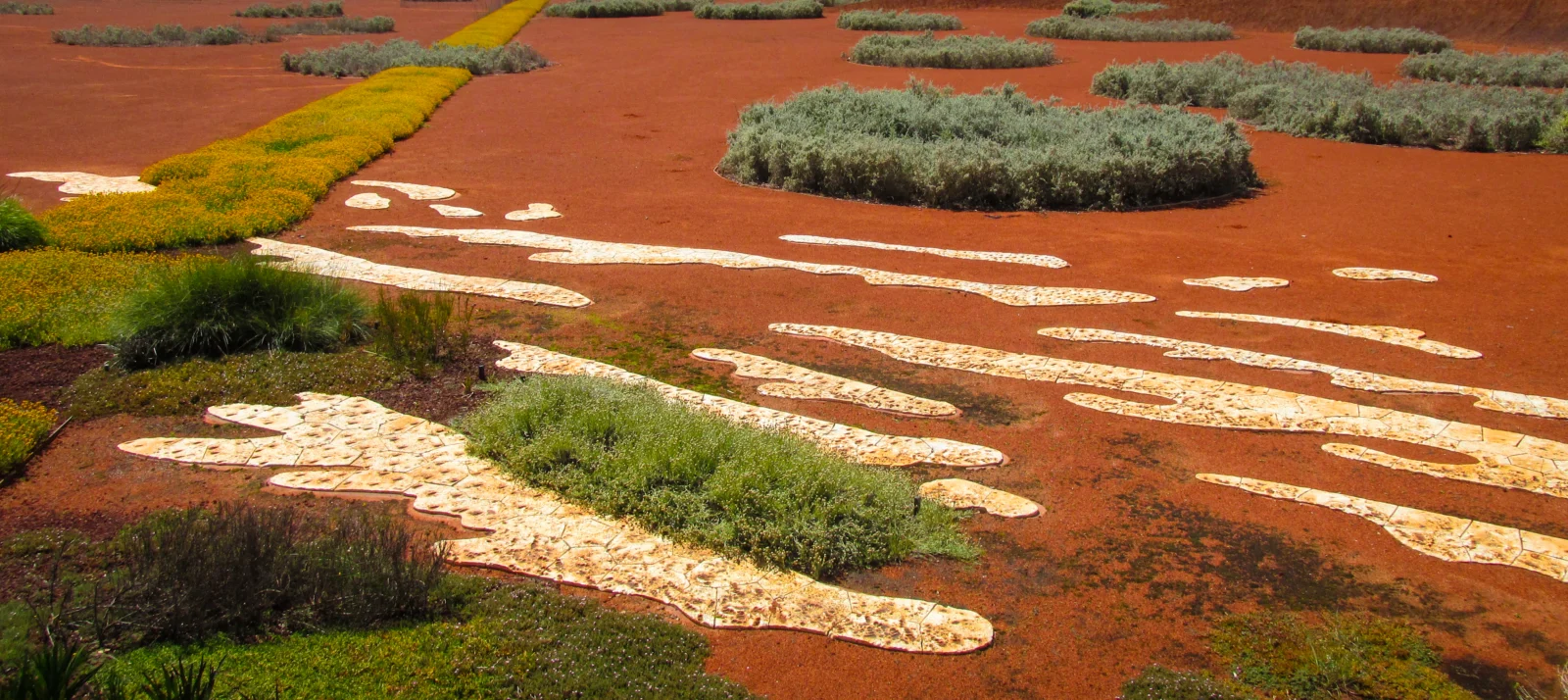 Red desert garden with Australian native plants and crescent shaped decorations