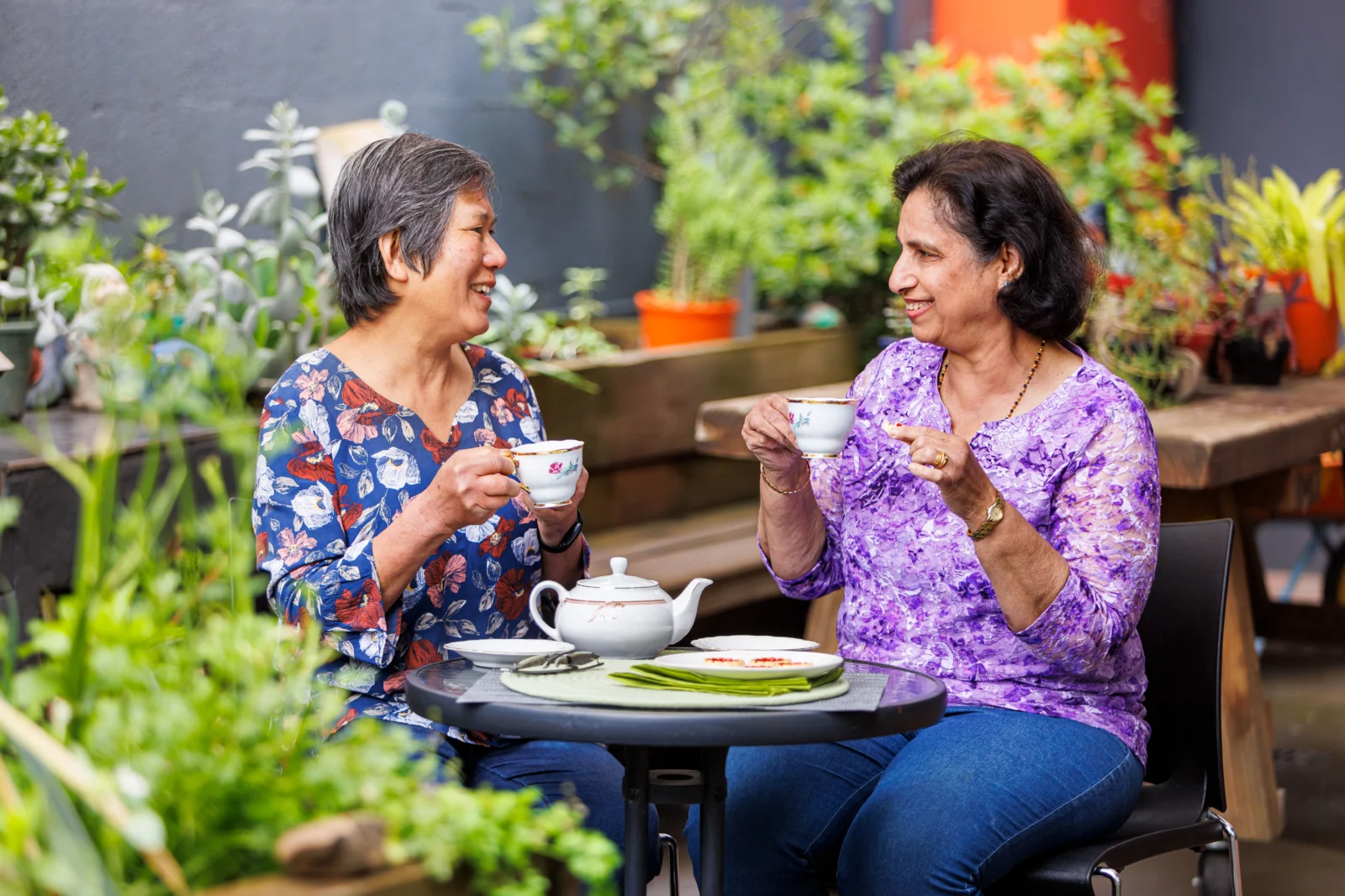 two older women sitting outside with a cup of tea