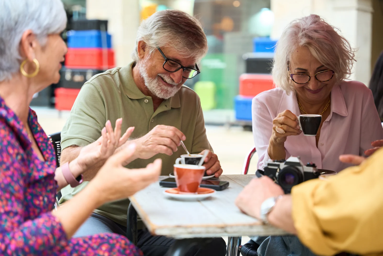 Group of older adults sitting at a table in a cafe
